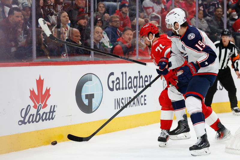 Nov 22, 2025; Detroit, Michigan, USA;  Detroit Red Wings center Dylan Larkin (71) and Columbus Blue Jackets center Adam Fantilli (19) battle for the puck in the second period at Little Caesars Arena. Mandatory Credit: Rick Osentoski-Imagn Images