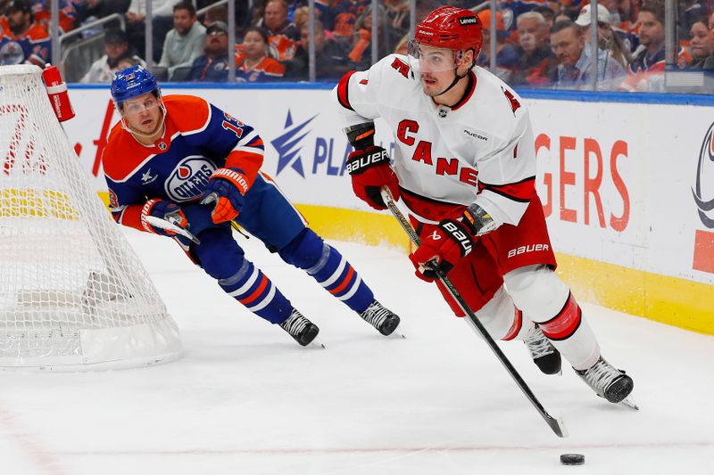 Oct 22, 2024; Edmonton, Alberta, CAN; Carolina Hurricanes defensemen Dmitery Orlov (7) looks to make a pass in front of Edmonton Oilers forward Mattias Janmark (13) during the third period at Rogers Place. Mandatory Credit: Perry Nelson-Imagn Images