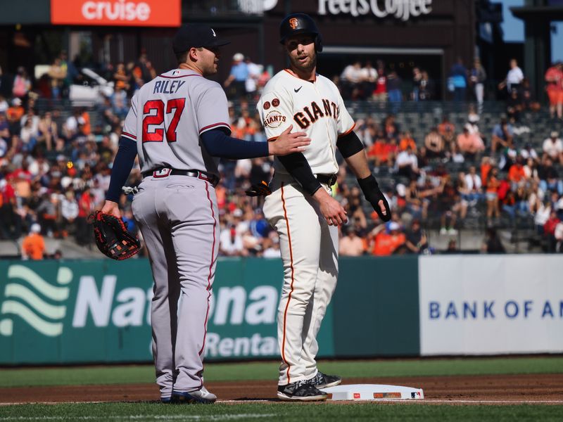 Aug 27, 2023; San Francisco, California, USA; Atlanta Braves third baseman Austin Riley (27) and San Francisco Giants center fielder Austin Slater (13) after Slater reached third base during the first inning at Oracle Park. Mandatory Credit: Kelley L Cox-USA TODAY Sports
