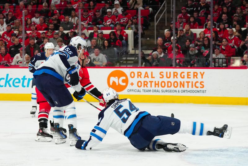 Mar 2, 2024; Raleigh, North Carolina, USA; Winnipeg Jets defenseman Dylan Samberg (54) and center Mark Scheifele (55) go out to stop the shot attempt by Carolina Hurricanes left wing Jordan Martinook (48) during the first period at PNC Arena. Mandatory Credit: James Guillory-USA TODAY Sports