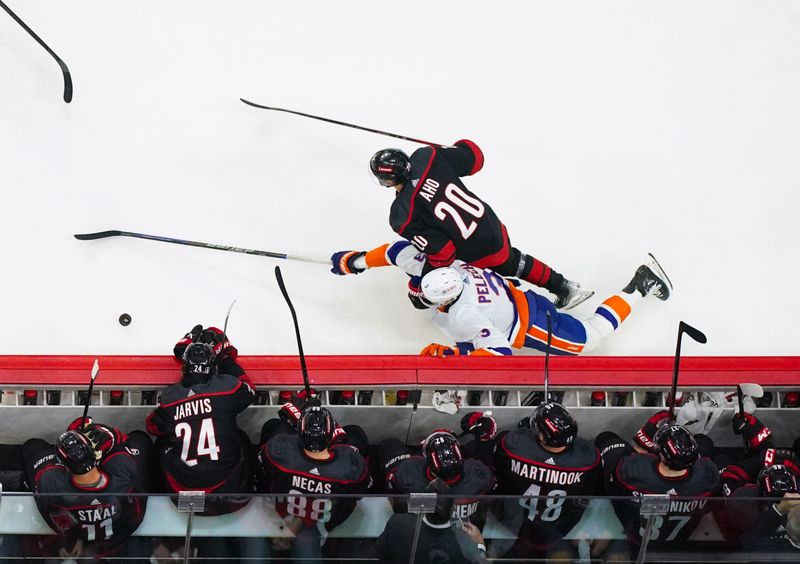 Apr 22, 2024; Raleigh, North Carolina, USA; New York Islanders defenseman Adam Pelech (3) is checked by Carolina Hurricanes center Sebastian Aho (20) during the first period in game two of the first round of the 2024 Stanley Cup Playoffs at PNC Arena. Mandatory Credit: James Guillory-USA TODAY Sports