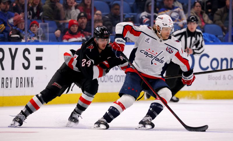 Jan 6, 2025; Buffalo, New York, USA;  Washington Capitals defenseman Jakob Chychrun (6) controls the puck as Buffalo Sabres center Dylan Cozens (24) defends during the third period at KeyBank Center. Mandatory Credit: Timothy T. Ludwig-Imagn Images