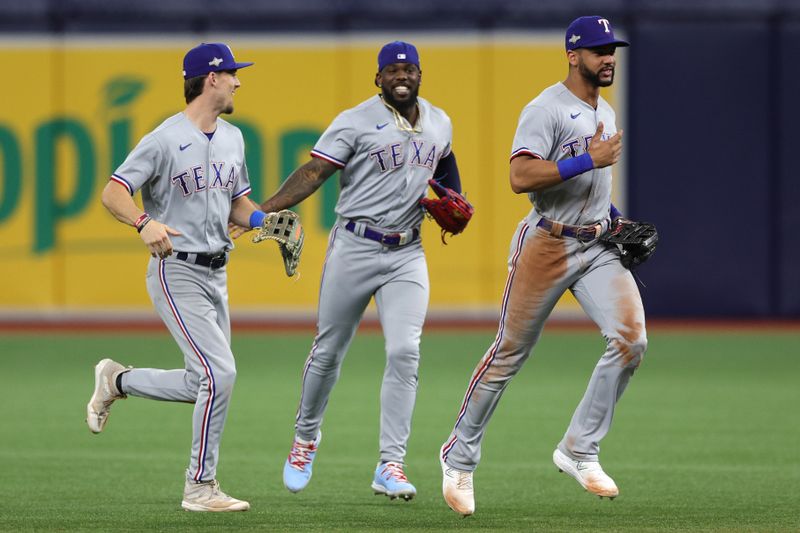 Oct 4, 2023; St. Petersburg, Florida, USA; (L to R) Texas Rangers left fielder Evan Carter (32), right fielder Adolis Garcia (53), and center fielder Leody Taveras (3) celebrate after defeating the Tampa Bay Rays in game two of the Wildcard series for the 2023 MLB playoffs at Tropicana Field. Mandatory Credit: Nathan Ray Seebeck-USA TODAY Sports