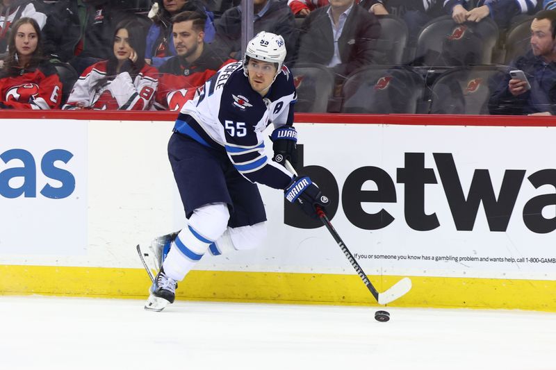 Mar 21, 2024; Newark, New Jersey, USA; Winnipeg Jets center Mark Scheifele (55) skates with the puck against the New Jersey Devils during the first period at Prudential Center. Mandatory Credit: Ed Mulholland-USA TODAY Sports