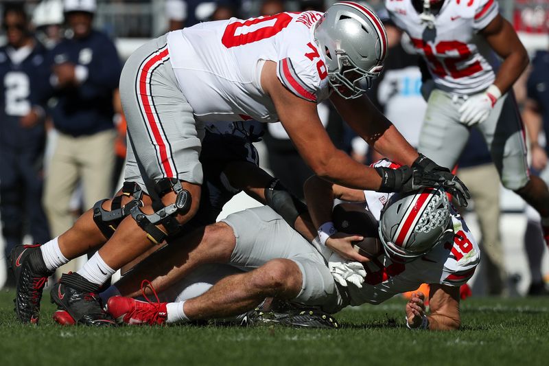 Nov 2, 2024; University Park, Pennsylvania, USA; Ohio State Buckeyes quarterback Will Howard (18) is sacked by Penn State Nittany Lions defensive end Abdul Carter (11) during the second quarter at Beaver Stadium. Mandatory Credit: Matthew O'Haren-Imagn Images