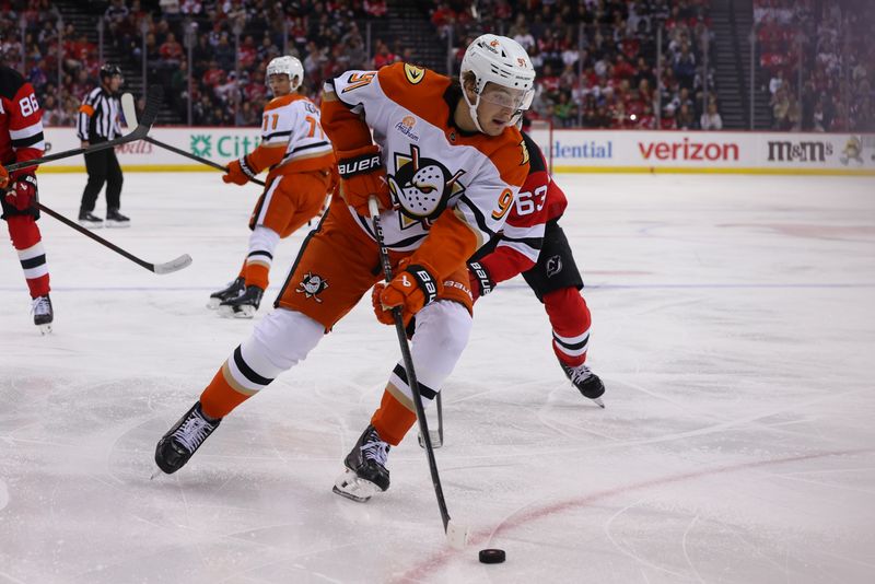 Oct 27, 2024; Newark, New Jersey, USA; Anaheim Ducks center Leo Carlsson (91) skates with the puck while being defended by New Jersey Devils left wing Jesper Bratt (63) during the second period at Prudential Center. Mandatory Credit: Ed Mulholland-Imagn Images