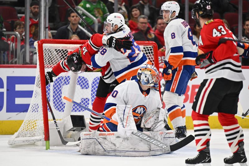 Jan 19, 2024; Chicago, Illinois, USA;  New York Islanders defenseman Alexander Romanov (28) collides with Chicago Blackhawks forward Jason Dickinson (16) behind goaltender Ilya Sorokin (30) in the first period at United Center. Mandatory Credit: Jamie Sabau-USA TODAY Sports