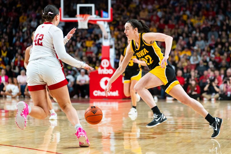 Feb 11, 2024; Lincoln, Nebraska, USA; Iowa Hawkeyes guard Caitlin Clark (22) drives against Nebraska Cornhuskers forward Jessica Petrie (12) during the third quarter at Pinnacle Bank Arena. Mandatory Credit: Dylan Widger-USA TODAY Sports