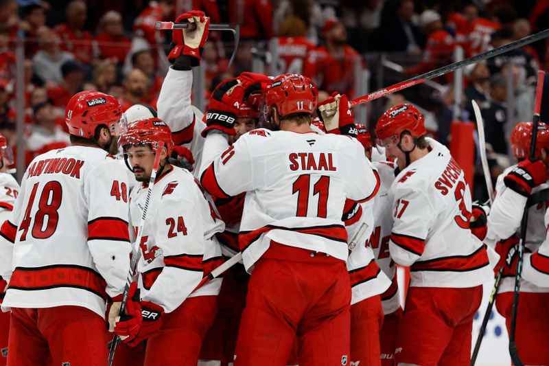 May 6, 2025; Washington, District of Columbia, USA; Carolina Hurricanes defenseman Jaccob Slavin (74) celebrates with teammates after scoring the game winning goal against the Washington Capitals in overtime in game one of the second round of the 2025 Stanley Cup Playoffs at Capital One Arena. Mandatory Credit: Geoff Burke-Imagn Images
