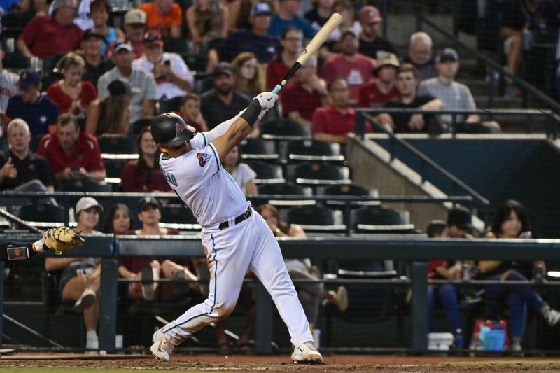 Sep 20, 2023; Phoenix, Arizona, USA;  Arizona Diamondbacks catcher Gabriel Moreno (14) hits an RBI single in the seventh inning against the San Francisco Giants at Chase Field. Mandatory Credit: Matt Kartozian-USA TODAY Sports