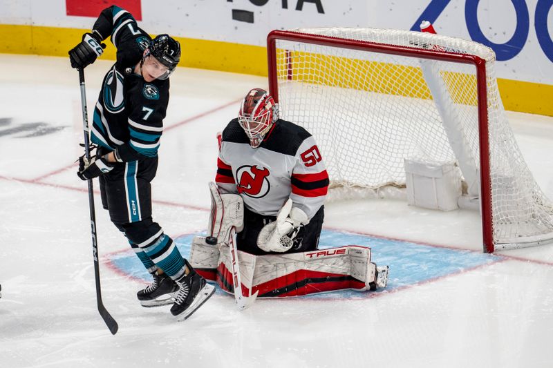 Feb 27, 2024; San Jose, California, USA;  New Jersey Devils goaltender Nico Daws (50) makes a save as San Jose Sharks center Nico Sturm (7) tries to deflect the puck into the net during the third period at SAP Center at San Jose. Mandatory Credit: Neville E. Guard-USA TODAY Sports