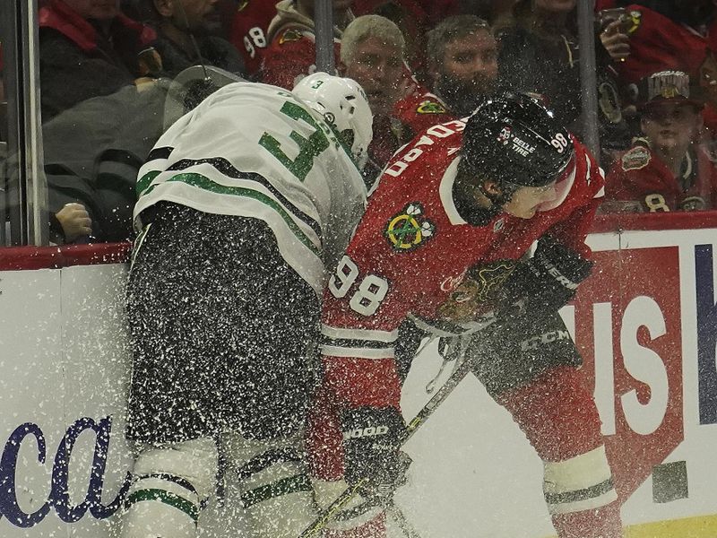 Nov 27, 2024; Chicago, Illinois, USA;Dallas Stars defenseman Mathew Dumba (3) and Chicago Blackhawks center Connor Bedard (98) scrap for the puck during the first period at United Center. Mandatory Credit: David Banks-Imagn Images