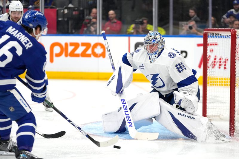 Oct 21, 2024; Toronto, Ontario, CAN; Tampa Bay Lightning goaltender Andrei Vasilevskiy (88) makes a save against Toronto Maple Leafs forward Mitch Marner (16) during the first period at Scotiabank Arena. Mandatory Credit: John E. Sokolowski-Imagn Images
