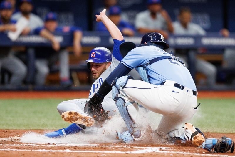 Jun 13, 2024; St. Petersburg, Florida, USA;  Chicago Cubs second baseman Michael Busch (29) scores a run past Tampa Bay Rays catcher Alex Jackson (28) in the fifth inning at Tropicana Field. Mandatory Credit: Nathan Ray Seebeck-USA TODAY Sports