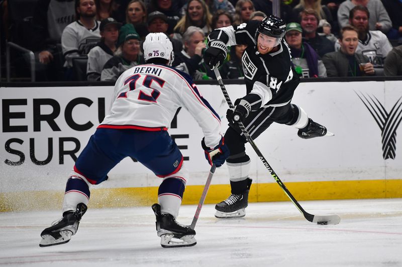 Mar 16, 2023; Los Angeles, California, USA; Los Angeles Kings defenseman Vladislav Gavrikov (84) shoots against the defense of Columbus Blue Jackets defenseman Tim Berni (75) during the second period at Crypto.com Arena. Mandatory Credit: Gary A. Vasquez-USA TODAY Sports