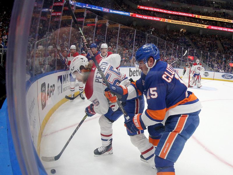 Apr 12, 2023; Elmont, New York, USA; Montreal Canadiens left wing Michael Pezzetta (55) plays the puck against New York Islanders right wing Cal Clutterbuck (15) during the second period at UBS Arena. Mandatory Credit: Brad Penner-USA TODAY Sports