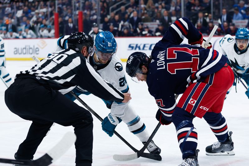 Oct 18, 2024; Winnipeg, Manitoba, CAN;  San Jose Sharks forward Alexander Wennberg (21) faces off against Winnipeg Jets forward Adam Lowry (17) during the first period at Canada Life Centre. Mandatory Credit: Terrence Lee-Imagn Images