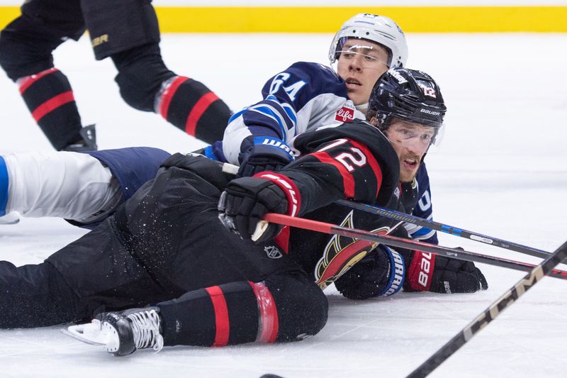 Jan 3, 2026; Ottawa, Ontario, CAN; Winnipeg Jets defenseman Logan Stanley (64) takes down Ottawa Senators defenseman Thomas Chabot (72) on a net drive in the first period at the Canadian Tire Centre. Mandatory Credit: Marc DesRosiers-IMAGN Images