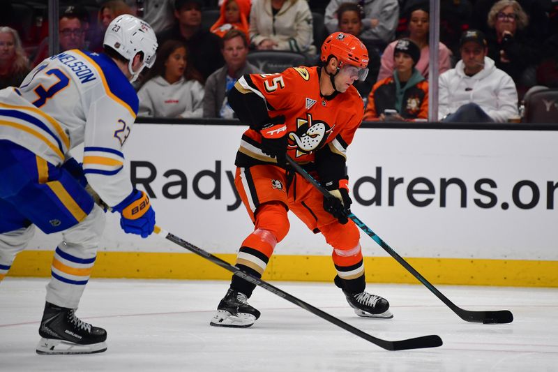 Mar 22, 2026; Anaheim, California, USA; Anaheim Ducks center Ryan Poehling (25) moves the puck against Buffalo Sabres defenseman Mattias Samuelsson (23) during the second period at Honda Center. Mandatory Credit: Gary A. Vasquez-Imagn Images