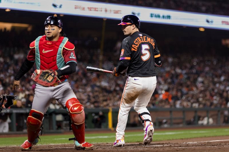May 13, 2025; San Francisco, California, USA; San Francisco Giants right fielder Mike Yastrzemski (5) watches as Arizona Diamondbacks catcher Gabriel Moreno (14) chases a missed catch to allow a run during the fifth inning at Oracle Park. Mandatory Credit: John Hefti-Imagn Images