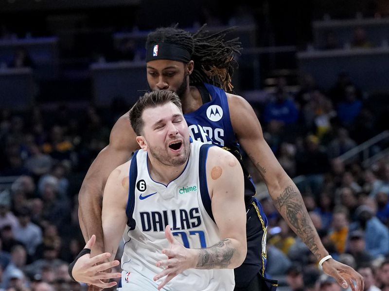 INDIANAPOLIS, INDIANA - MARCH 27: Luka Doncic #77 of the Dallas Mavericks dribbles the ball while being fouled by Isaiah Jackson #22 of the Indiana Pacers in the first quarter at Gainbridge Fieldhouse on March 27, 2023 in Indianapolis, Indiana. NOTE TO USER: User expressly acknowledges and agrees that, by downloading and or using this photograph, User is consenting to the terms and conditions of the Getty Images License Agreement. (Photo by Dylan Buell/Getty Images)
