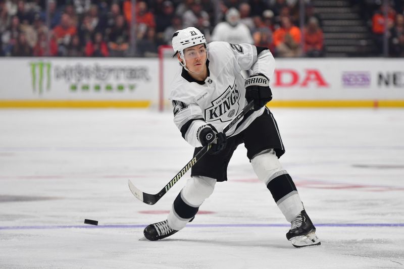 Nov 29, 2024; Anaheim, California, USA; Los Angeles Kings defenseman Jordan Spence (21) passes the puck against the Anaheim Ducks during the third period at Honda Center. Mandatory Credit: Gary A. Vasquez-Imagn Images