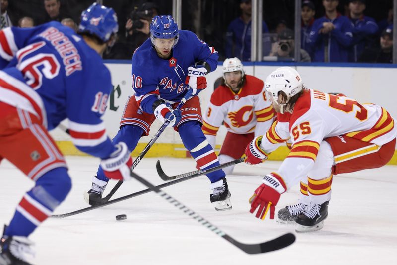 Feb 12, 2024; New York, New York, USA; New York Rangers left wing Artemi Panarin (10) looks to pass the puck to center Vincent Trocheck (16) against Calgary Flames defensemen Chris Tanev (8) and Noah Hanifin (55) during the first period at Madison Square Garden. Mandatory Credit: Brad Penner-USA TODAY Sports