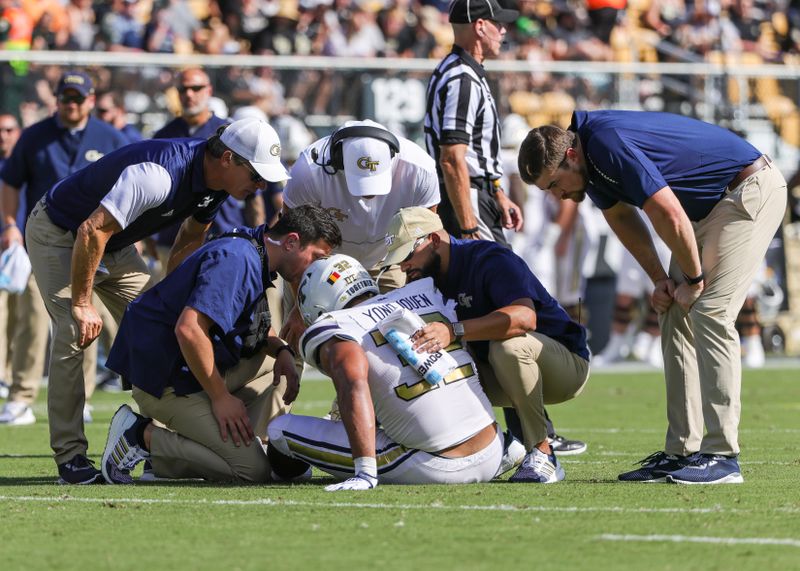 Sep 24, 2022; Orlando, Florida, USA; Georgia Tech Yellow Jackets trainers attend to Georgia Tech Yellow Jackets defensive lineman Sylvain Yondjouen (32) who was injured during the first quarter against the UCF Knights at FBC Mortgage Stadium. Mandatory Credit: Mike Watters-USA TODAY Sports