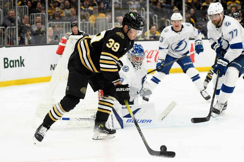 Feb 13, 2024; Boston, Massachusetts, USA;  Boston Bruins center Morgan Geekie (39) controls the puck in front of Tampa Bay Lightning goaltender Andrei Vasilevskiy (88) and defenseman Victor Hedman (77) during the third period at TD Garden. Mandatory Credit: Bob DeChiara-USA TODAY Sports