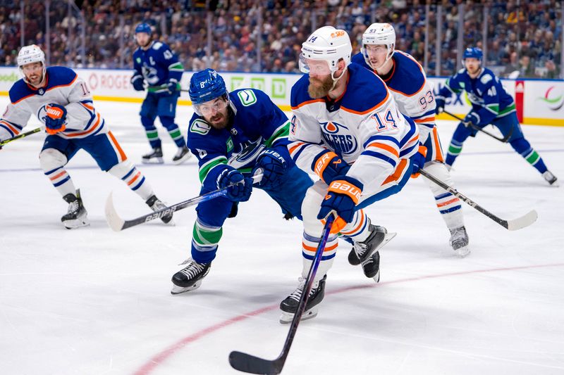 May 20, 2024; Vancouver, British Columbia, CAN; Vancouver Canucks forward Conor Garland (8) stick checks Edmonton Oilers defenseman Mattias Ekholm (14) during the third period in game seven of the second round of the 2024 Stanley Cup Playoffs at Rogers Arena. Mandatory Credit: Bob Frid-USA TODAY Sports