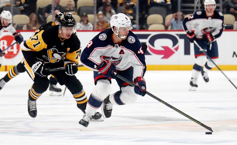 Oct 4, 2024; Pittsburgh, Pennsylvania, USA;  Columbus Blue Jackets center Cole Sillinger (4) skates up ice with the puck as Pittsburgh Penguins center Evgeni Malkin (7) chases during the second period at PPG Paints Arena. Mandatory Credit: Charles LeClaire-Imagn Images