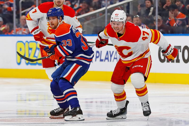 Oct 13, 2024; Edmonton, Alberta, CAN; Edmonton Oilers forward Victor Arvidsson (33) and Calgary Flames forward Connor Zary (47) battle for position  during the second period at Rogers Place. Mandatory Credit: Perry Nelson-Imagn Images