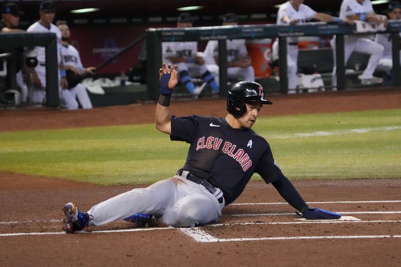 Jun 18, 2023; Phoenix, Arizona, USA; Cleveland Guardians left fielder Steven Kwan (38) slides and scores a run against the Arizona Diamondbacks during the first inning at Chase Field. Mandatory Credit: Joe Camporeale-USA TODAY Sports