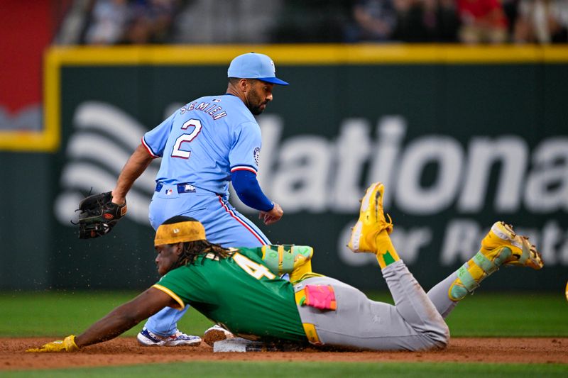 Sep 1, 2024; Arlington, Texas, USA; Oakland Athletics right fielder Lawrence Butler (4) slides past the tag of Texas Rangers second baseman Marcus Semien (2) during the third inning at Globe Life Field. Mandatory Credit: Jerome Miron-USA TODAY Sports