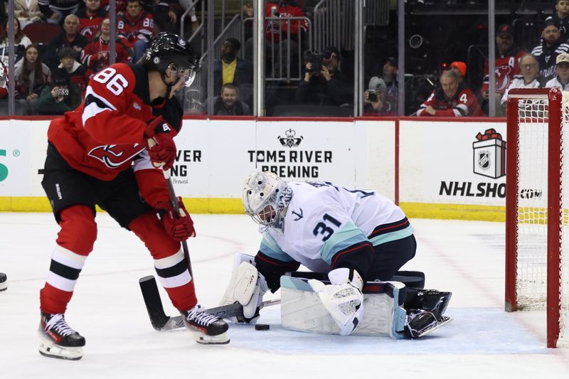 Dec 6, 2024; Newark, New Jersey, USA; Seattle Kraken goaltender Philipp Grubauer (31) makes a save on New Jersey Devils center Jack Hughes (86) during the second period at Prudential Center. Mandatory Credit: Ed Mulholland-Imagn Images
