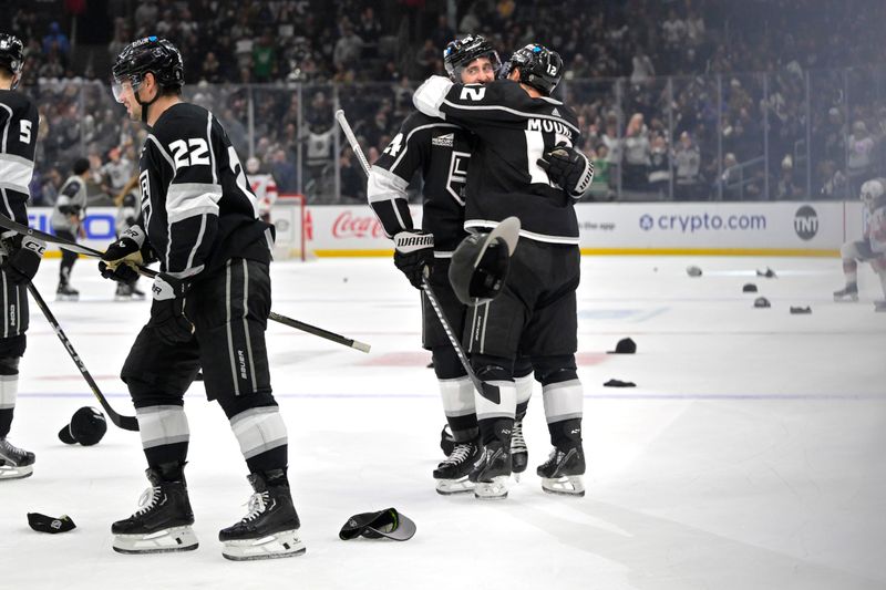 Mar 3, 2024; Los Angeles, California, USA; Hats litter the ice as Los Angeles Kings center Phillip Danault (24) is congratulated by Los Angeles Kings left wing Trevor Moore (12) after scoring a hat trick in the third period against the New Jersey Devils at Crypto.com Arena. Mandatory Credit: Jayne Kamin-Oncea-USA TODAY Sports