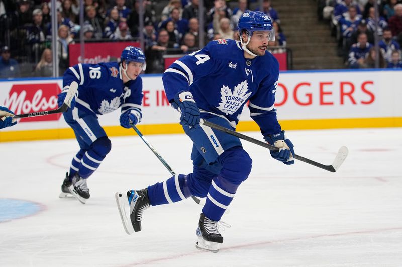 Jan 13, 2024; Toronto, Ontario, CAN; Toronto Maple Leafs forward Auston Matthews (34) and forward Mitchell Marner (16) head up ice against the Colorado Avalanche during the third period at Scotiabank Arena. Mandatory Credit: John E. Sokolowski-USA TODAY Sports