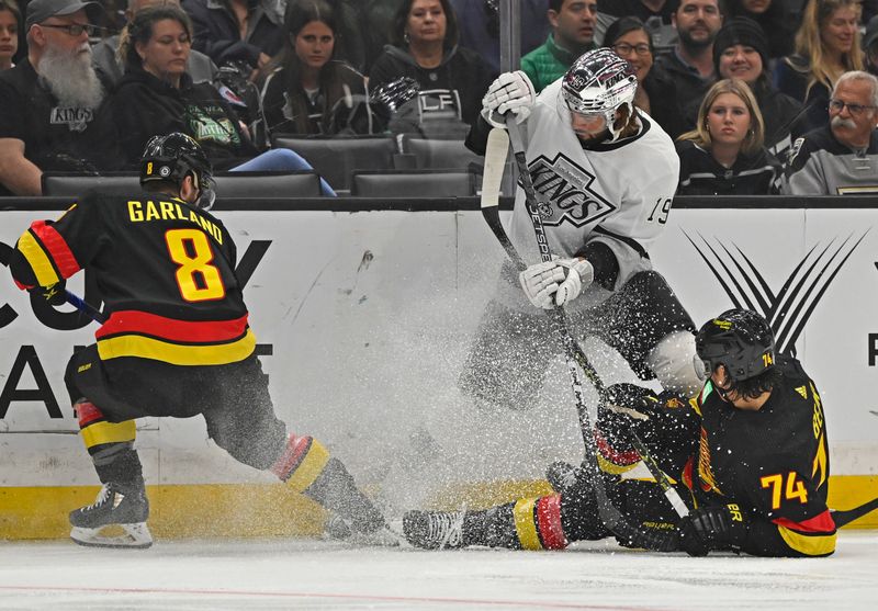 Apr 10, 2023; Los Angeles, California, USA;  Vancouver Canucks right wing Conor Garland (8) and defenseman Ethan Bear (74) and Los Angeles Kings left wing Alex Iafallo (19) battle for the puck in the first period at Crypto.com Arena. Mandatory Credit: Jayne Kamin-Oncea-USA TODAY Sports