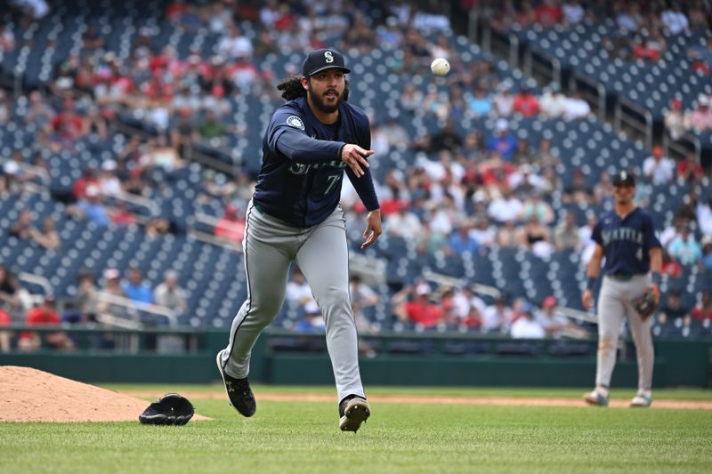 May 26, 2024; Washington, District of Columbia, USA; Seattle Mariners relief pitcher Andres Munoz (75) tosses the ball to first base for an out against the Washington Nationals during the ninth inning at Nationals Park. Mandatory Credit: Rafael Suanes-USA TODAY Sports