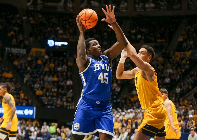 Feb 3, 2024; Morgantown, West Virginia, USA; Brigham Young Cougars forward Fousseyni Traore (45) shoots in the lane against West Virginia Mountaineers center Jesse Edwards (7) during the first half at WVU Coliseum. Mandatory Credit: Ben Queen-USA TODAY Sports