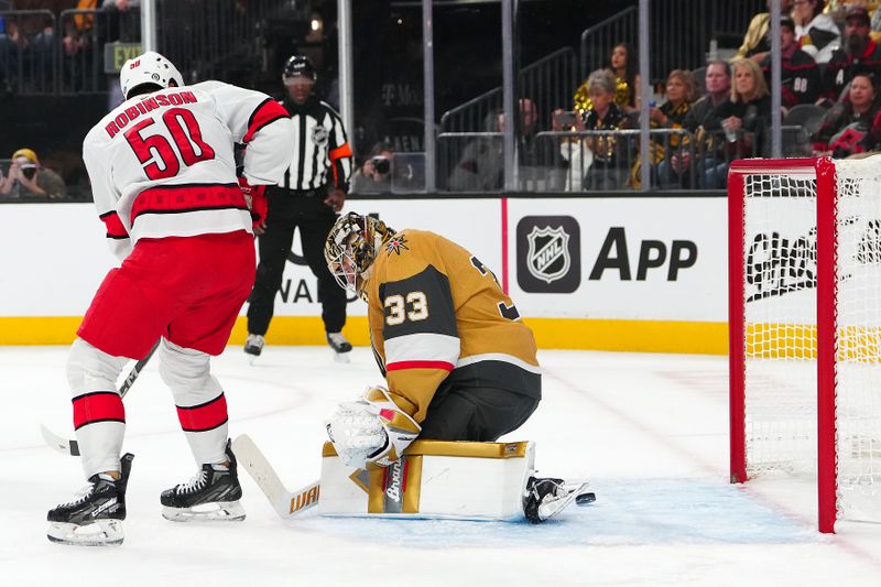 Nov 11, 2024; Las Vegas, Nevada, USA; Carolina Hurricanes left wing Eric Robinson (50) deflects the puck between the legs of Vegas Golden Knights goaltender Adin Hill (33) to score as goal during the first period at T-Mobile Arena. Mandatory Credit: Stephen R. Sylvanie-Imagn Images