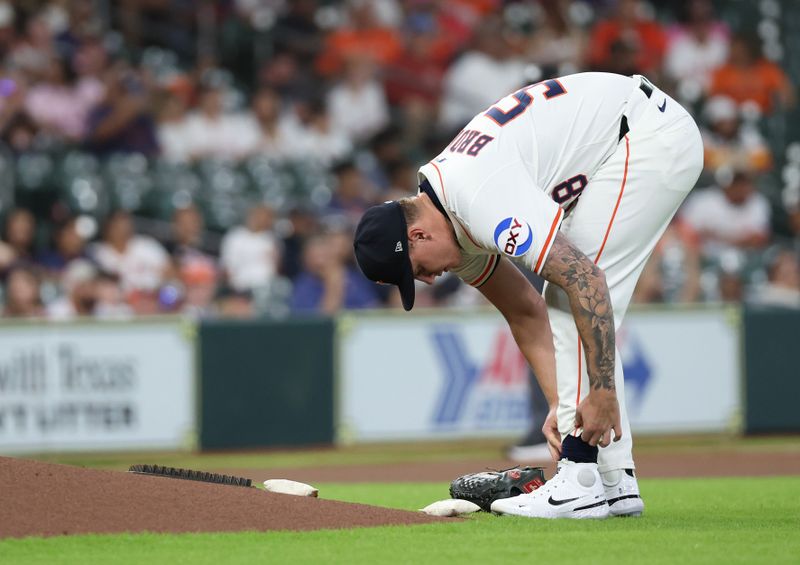 May 27, 2025; Houston, Texas, USA;Houston Astros starting pitcher Hunter Brown (58) ties his shoe before pitching against the Athletics  in the first inning  at Daikin Park. Mandatory Credit: Thomas Shea-Imagn Images