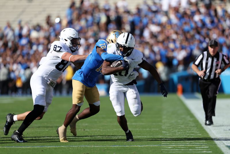 Oct 4, 2025; Pasadena, California, USA;  Penn State Nittany Lions running back Nicholas Singleton (10) is tackled by UCLA Bruins defensive back Rodrick Pleasant (18) during the fourth quarter at Rose Bowl. Mandatory Credit: Kiyoshi Mio-Imagn Images