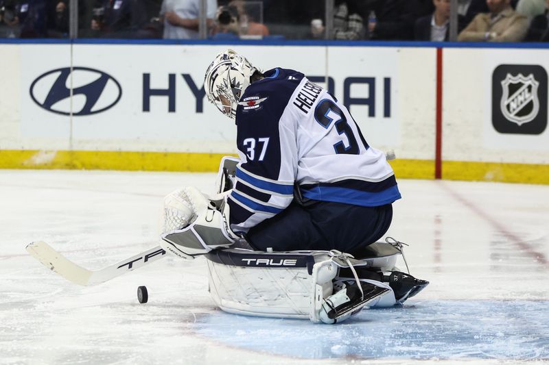 Nov 12, 2024; New York, New York, USA;  Winnipeg Jets goaltender Connor Hellebuyck (37) deflects the puck in the second period against the New York Rangers at Madison Square Garden. Mandatory Credit: Wendell Cruz-Imagn Images