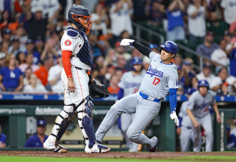 Jul 27, 2024; Houston, Texas, USA; Los Angeles Dodgers designated hitter Shohei Ohtani (17) slides past Houston Astros catcher Yainer Diaz (21) to score a run during the fifth inning at Minute Maid Park. Mandatory Credit: Troy Taormina-USA TODAY Sports