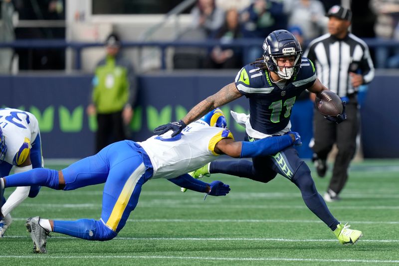 Seattle Seahawks wide receiver Jaxon Smith-Njigba (11) runs against Los Angeles Rams safety Kamren Curl during the first half of an NFL football game in Seattle, Sunday, Nov. 3, 2024. (AP Photo/Stephen Brashear)