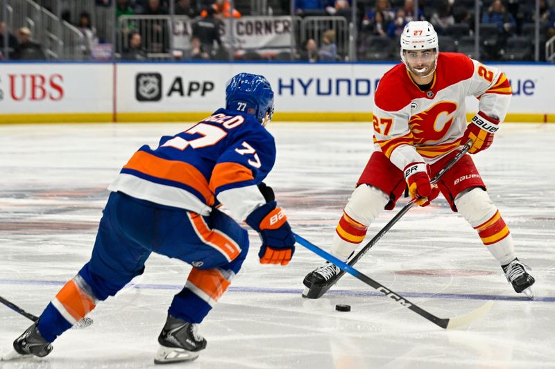 Mar 14, 2026; Elmont, New York, USA; Calgary Flames right wing Matt Coronato (27) skates across the blue defended by New York Islanders defenseman Tony DeAngelo (77) during the third period at UBS Arena. Mandatory Credit: Dennis Schneidler-Imagn Images Mar 14, 2026; Elmont, New York, USA; Calgary Flames right wing Matt Coronato (27) skates across the blue defended by New York Islanders defenseman Tony DeAngelo (77) during the third period at UBS Arena. Mandatory Credit: Dennis Schneidler-Imagn Images