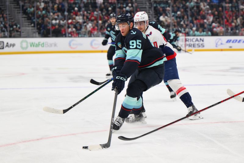 Jan 23, 2025; Seattle, Washington, USA; Seattle Kraken left wing Andre Burakovsky (95) plays the puck while defended by Washington Capitals left wing Pierre-Luc Dubois (80) during the first period at Climate Pledge Arena. Mandatory Credit: Steven Bisig-Imagn Images