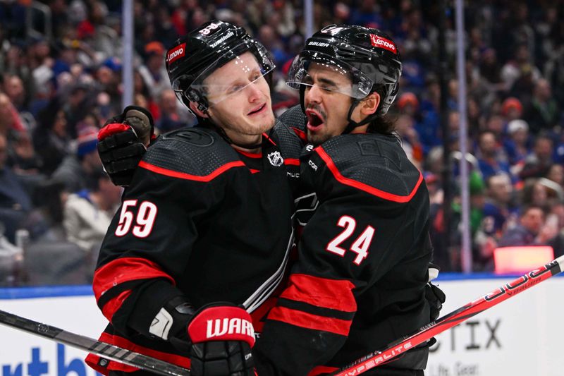 Mar 19, 2024; Elmont, New York, USA; Carolina Hurricanes center Seth Jarvis (24) celebrates his second goal against the New York Islanders with Carolina Hurricanes left wing Jake Guentzel (59) during the first period at UBS Arena. Mandatory Credit: Dennis Schneidler-USA TODAY Sports