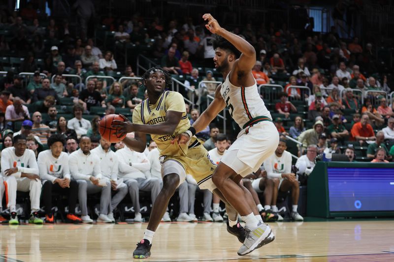 Feb 24, 2024; Coral Gables, Florida, USA; Georgia Tech Yellow Jackets forward Baye Ndongo (11) protects the basketball from Miami Hurricanes forward Norchad Omier (15) during the first half at Watsco Center. Mandatory Credit: Sam Navarro-USA TODAY Sports